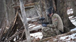Man dressed in camo with paintball gun